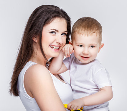 happy mother with a child on light grey background
