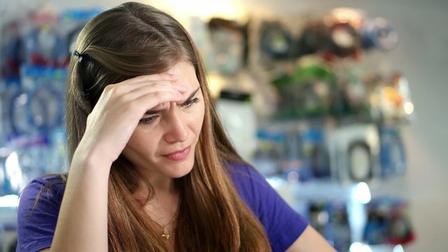 Worried Woman Checking Bills And Invoices In Computer Shop