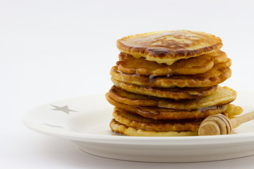 Stack of pancakes with honey on the plate isolated 