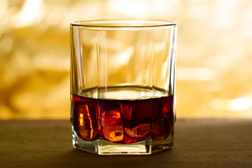 whiskey with ice on a wooden table