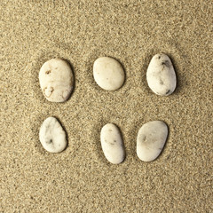 Fototapeta na wymiar six stones in the sand