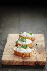 crunchy baguette slices with cream cheese and green onion on
