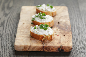 crunchy baguette slices with cream cheese and green onion on