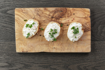 crunchy baguette slices with cream cheese and green onion on