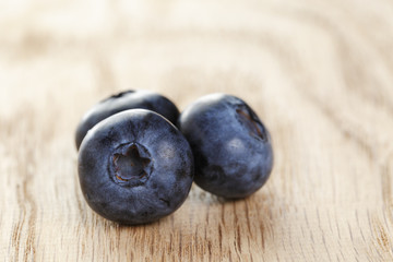 three fresh washed blueberries on wooden table