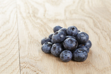 heap of fresh washed blueberries on wooden table