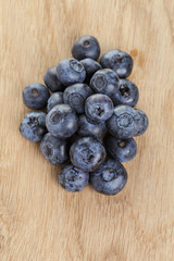 heap of fresh washed blueberries on wooden table