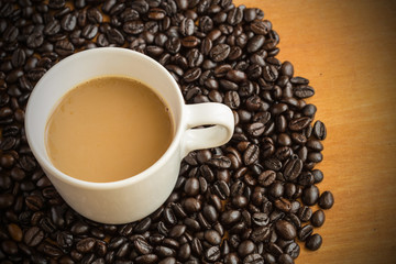 Hot latte coffee cup on coffee beans background.