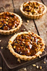 Gordijnen Tart with nuts and caramel on a rustic  background © anna_shepulova