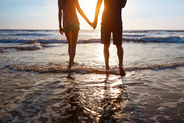 Fototapeta na wymiar Young couple walking on the beach
