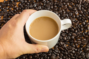 Hot latte coffee cup on coffee beans background.