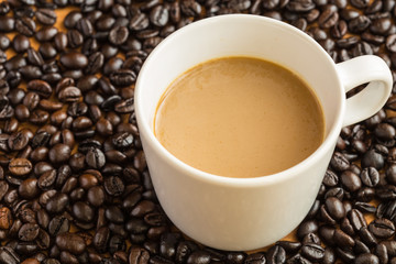 Hot latte coffee cup on coffee beans background.