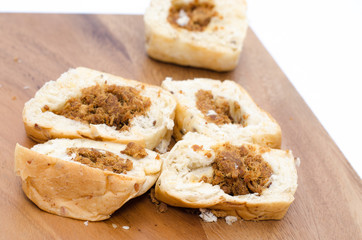Bread slices on wood cutting board on white background