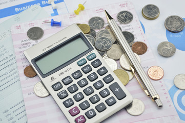 Calculator, pen, pin and coin on saving book