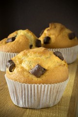 Chocolate chip muffins on a dark wooden background