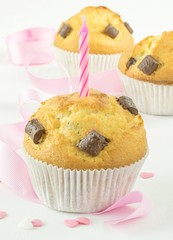 Chocolate chip muffins with birthday candle and pink decorations