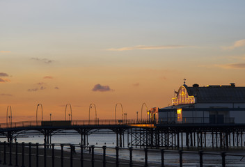 Seaside pier in Cleethorpes at sunset, orange sky reflecting on the front of the building