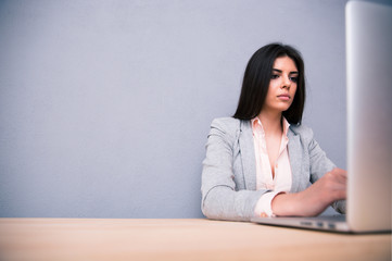 Businesswoman sitting at the table with laptop