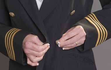 Airline officer fastening button on her uniform