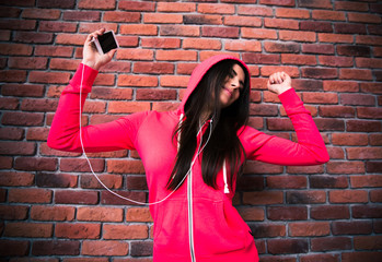 Smiling young girl listening music and dancing in headphones