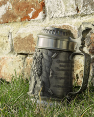 beer mug on the grass near the brick wall