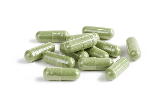 Capsules Of Green Herbal Supplement Product Isolated On White Ba