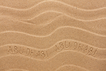 Abu Dhabi  inscription on the wavy sand