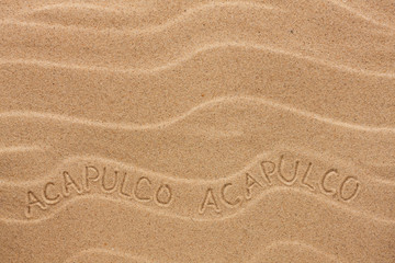 Acapulco  inscription on the wavy sand