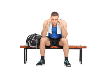 Worried athlete sitting on a bench