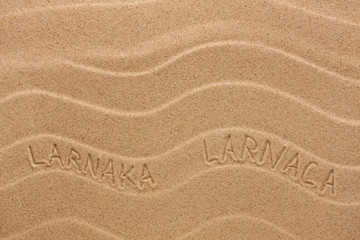 Larnaca inscription on the wavy sand
