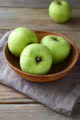 Green apples in a bowl on napkin