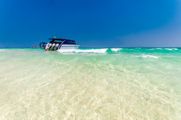 Boat docking in front of the white sand beach