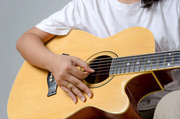Female hand playing music by acoustic guitar - Close up shot and