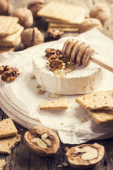 camembert cheese with crackers, nuts and honey