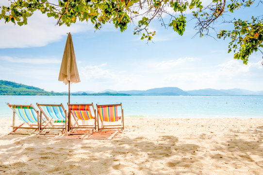 Empty beach chairs on a sunny day at Rang Yai iland, Thailand