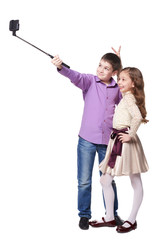 Boy and girl taking selfies with selfiestick on her smartphone