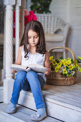 Little cute girl reading a book