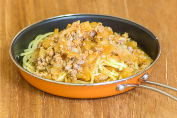 spaghetti with tomato sauce on wood background