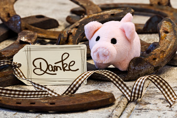 Glücksbringer mit Schild auf Holz, Danke