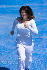 Laufende Frau im leeren Schwimmbecken