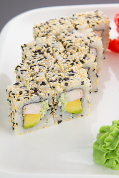 Japanese tasty sushi set on a white plate over black background