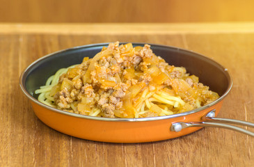 spaghetti with tomato sauce on wood background