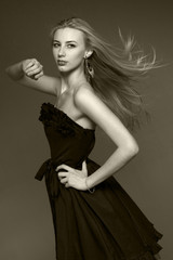 Fototapeta premium portrait of blond woman in a black dress in the studio