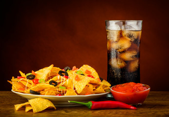 nachos, salsa dip and cola drink