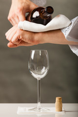 Man waiter pouring wine into glass.