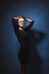 European appearance blonde girl with glasses in a black dress ho