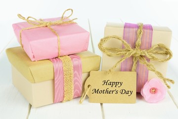 Handmade gift boxes with Happy Mother's Day tag on white wood