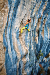 Rock climber climbing up a cliff
