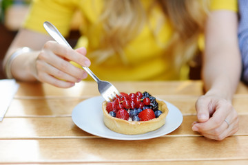 Woman eating custard fruit tart