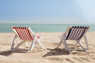 Two Deckchairs On Beach